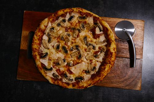 a pizza sitting on top of a wooden cutting board